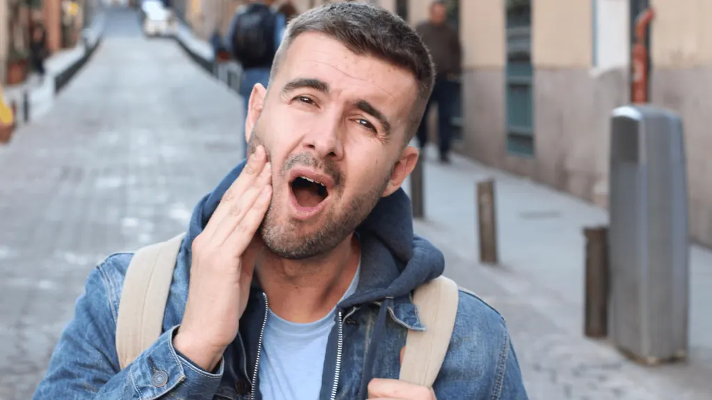 Homem com dor na mandíbula, sintoma de DTM relacionado ao bruxismo