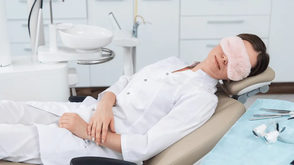 Paciente relaxando com máscara de dormir na cadeira odontológica, ilustrando a conexão entre odontologia e saúde do sono