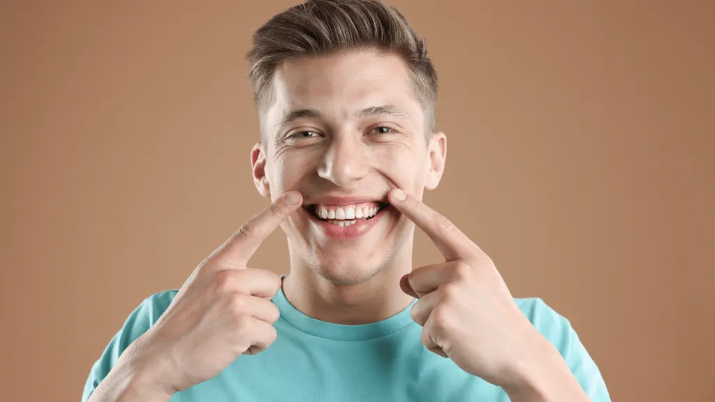 Pessoa sorrindo mostrando dentes clareados, ilustrando o custo do clareamento dental