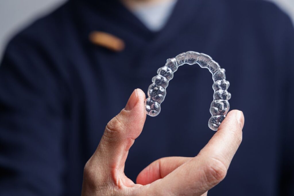 Alinhadores invisíveis sendo colocados em dentes perfeitamente alinhados